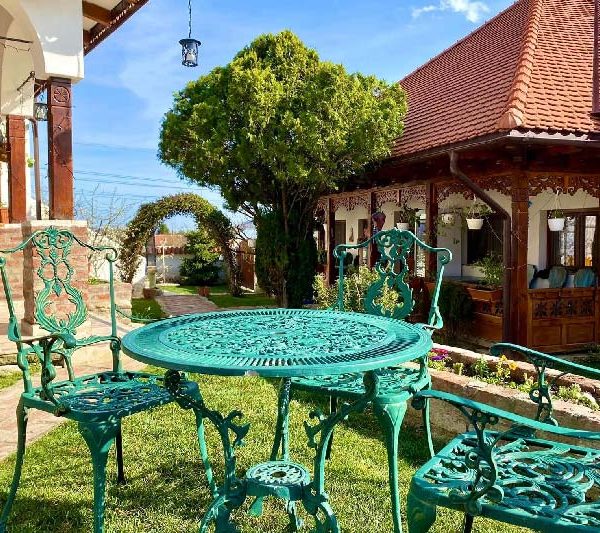 Guests at a table in the manor garden at Conacul Grigorescu